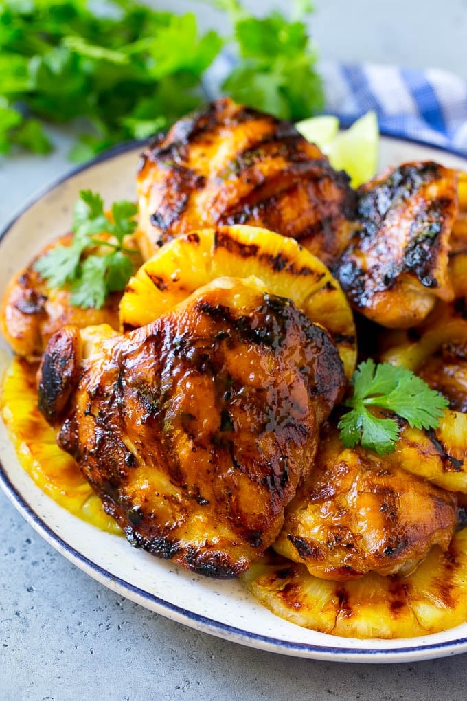 Grilled Hawaiian chicken thighs with pineapple and cilantro on a plate.