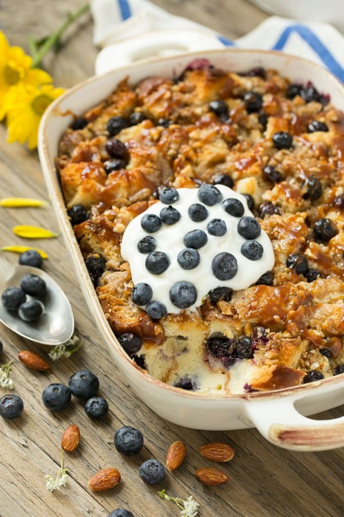 Blueberry Bread Pudding Recipe | Blueberry Bread Pudding | Easy Bread Pudding #blueberry #breadpudding #dessert #sadud A pan of blueberry bread pudding topped with streusel and caramel sauce.