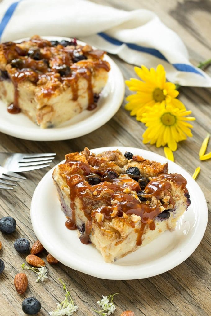Blueberry Bread Pudding Recipe | Blueberry Bread Pudding | Easy Bread Pudding #blueberry #breadpudding #dessert #sadud Two pieces of blueberry bread pudding on plates with salted caramel on top.