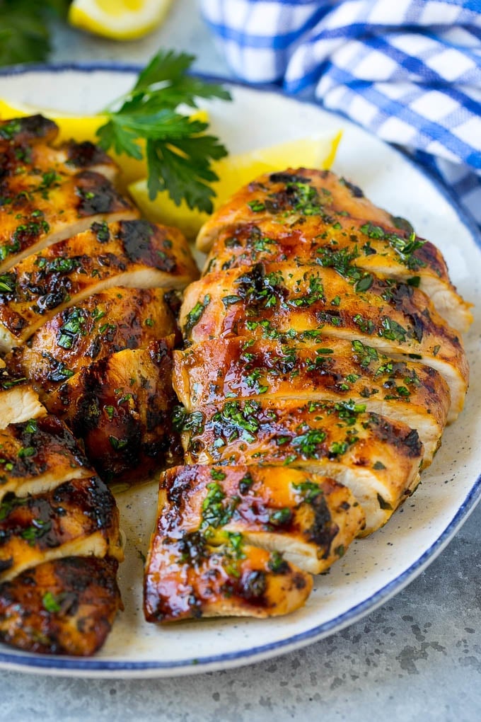 Grilled Chicken Breast Recipe | Marinated Chicken Breast | Chicken Marinade #chicken #grilling #marinade #summer #dinner #sadud Sliced grilled chicken breast garnished with herbs and lemon.