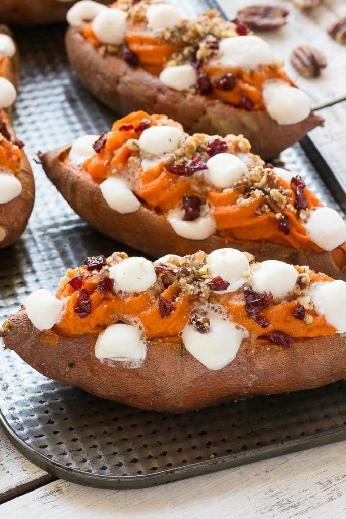 Cooked sweet spuds on a tray with melting marshmallows.