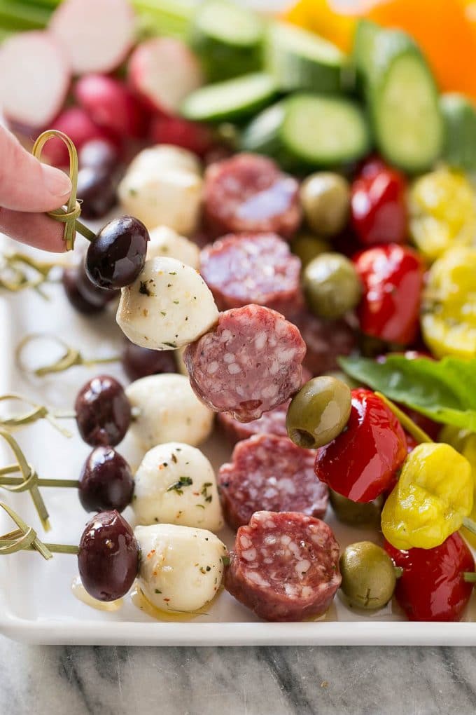 Antipasto Skewers Recipe | Easy Antipasto | Best Antipasto #antipasto #skewers #appetizer #sadud A hand holding up a skewer of salami, cheese and olives.