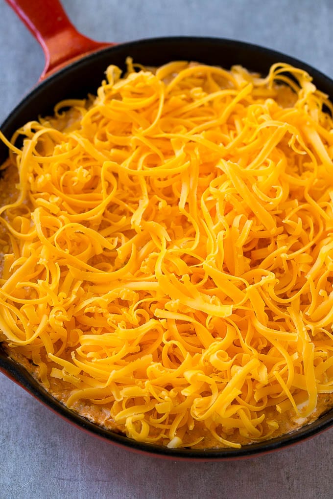 Buffalo Ranch Chicken Dip | Buffalo Chicken Dip | Baked Buffalo Dip | Cheesy Buffalo Dip #buffalowings #buffalochicken #dip #lowcarb #appetizer #sadud Buffalo chicken dip topped with shredded cheddar cheese, ready to go into the oven.