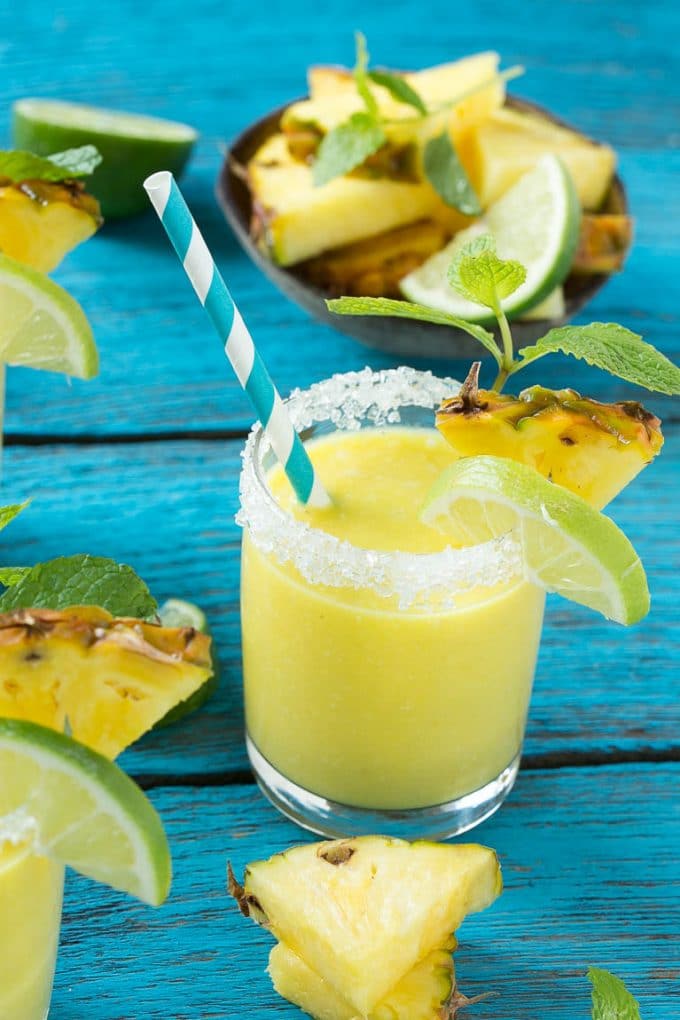 Pineapple Coconut Smoothie Recipe |Tropical Smoothie | Pineapple Smoothie #smoothie #pineapple #coconut #healthy #cleaneating #sadud A tropical smoothie with a paper straw in it.