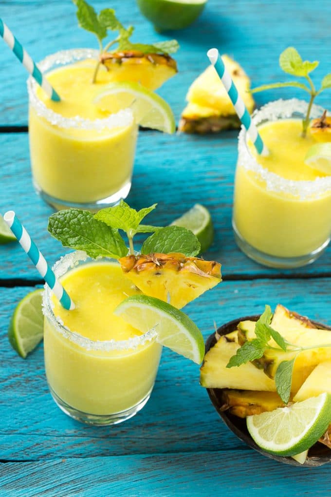 Pineapple Coconut Smoothie Recipe |Tropical Smoothie | Pineapple Smoothie #smoothie #pineapple #coconut #healthy #cleaneating #sadud Pineapple coconut smoothies in glasses with sugared rims.