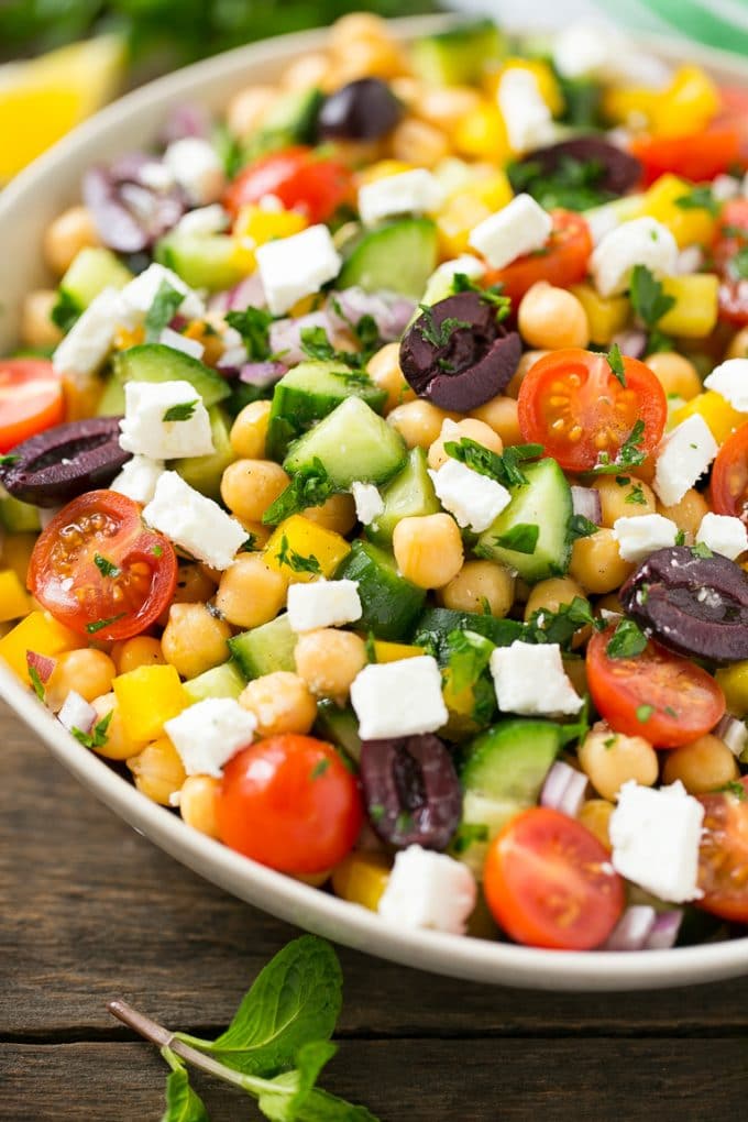 Greek Salad | Chopped Greek salad | Chopped Salad #salad #vegetarian #cheese #chickpeas #lunch #sadud Cucumbers, chickpeas, olives, tomatoes, peppers and feta cheese in a serving bowl.