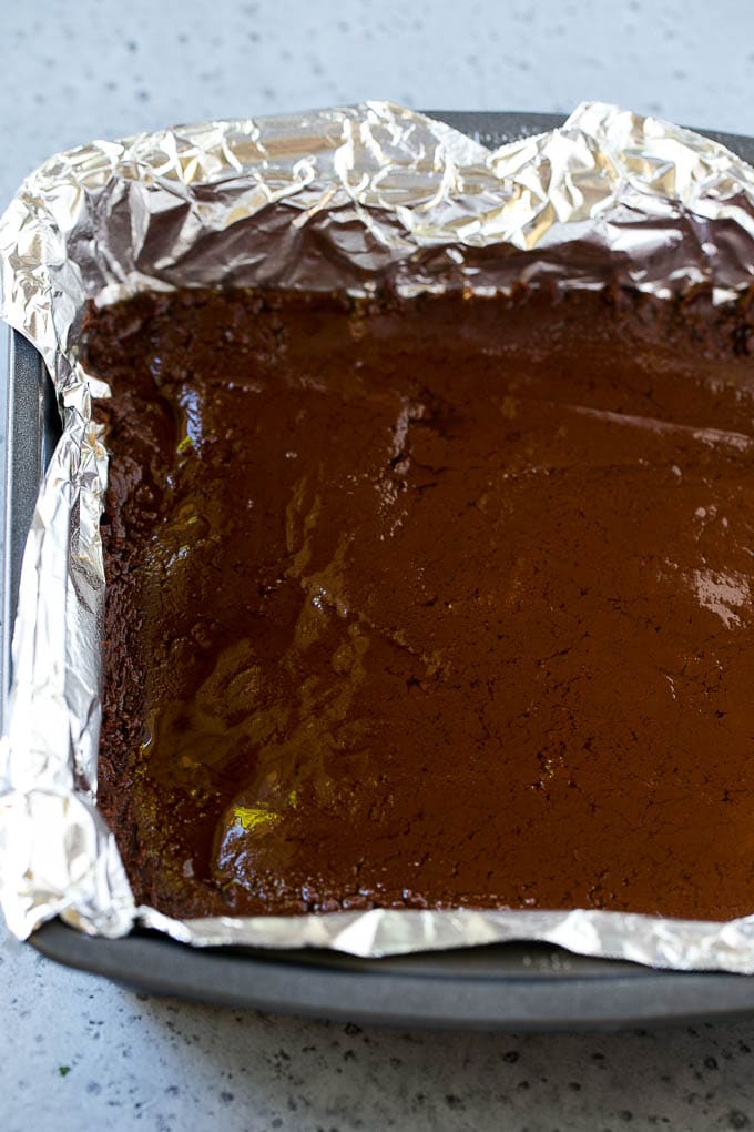 Chocolate Peanut Butter Fudge Recipe | Peanut Butter Cup Fudge | Easy Fudge Recipe #chocolate #peanutbutter #fudge #baking #dessert #sadud A layer of chocolate fudge in a pan.