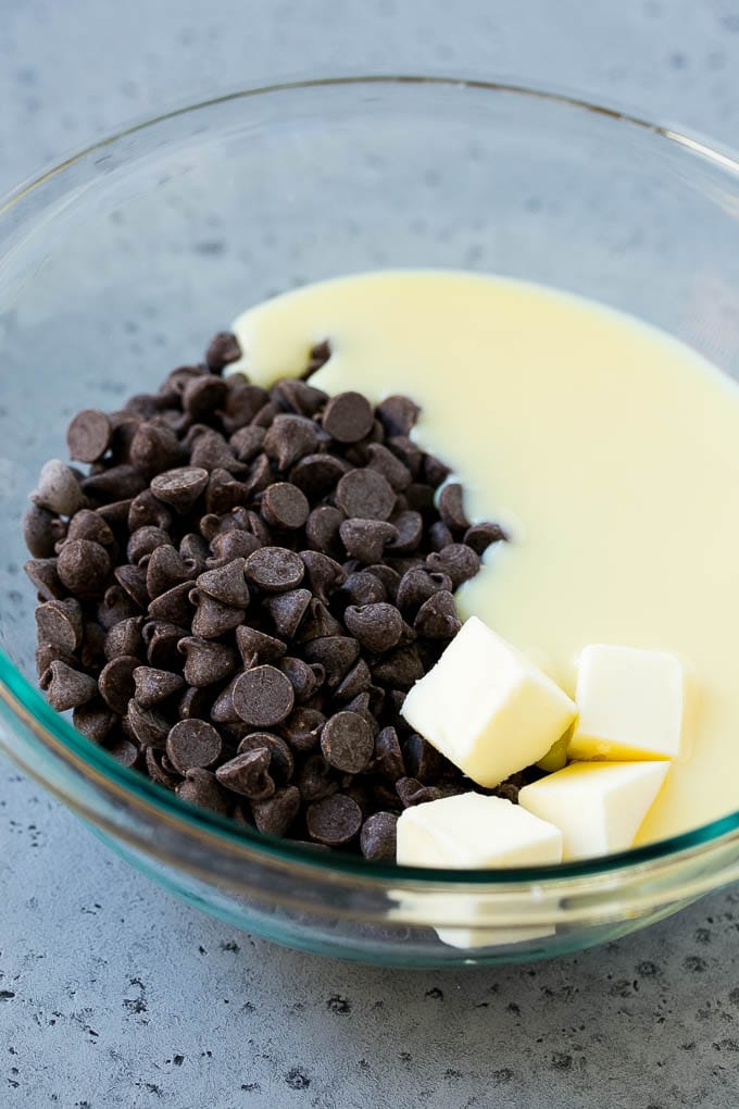 Chocolate Peanut Butter Fudge Recipe | Peanut Butter Cup Fudge | Easy Fudge Recipe #chocolate #peanutbutter #fudge #baking #dessert #sadud Chocolate chips, condensed milk and butter in a mixing bowl.