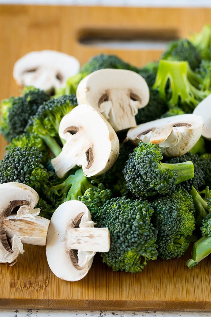 Chicken and Broccoli Stir Fry Recipe | Chicken Stir Fry | Healthy Chicken Recipe | Chicken and Broccoli | Chinese Food #chicken #broccoli #stirfry #healthy #cleaneating #dinner #sadud Broccoli florets and sliced mushrooms on a cutting board.