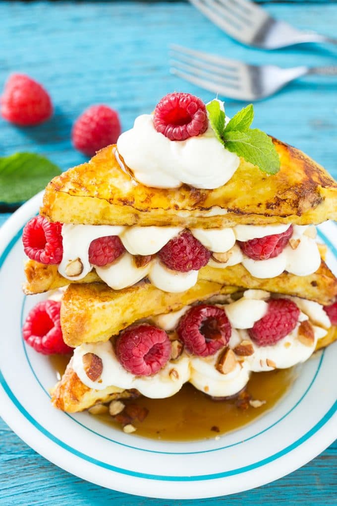 Stuffed French Toast | Cream Cheese Stuffed French Toast | French Toast Recipe #frenchtoast #raspberry #creamcheese #breakfast #brunch #sadud A plate of cooked brioche filled with cream cheese, berries and almonds.