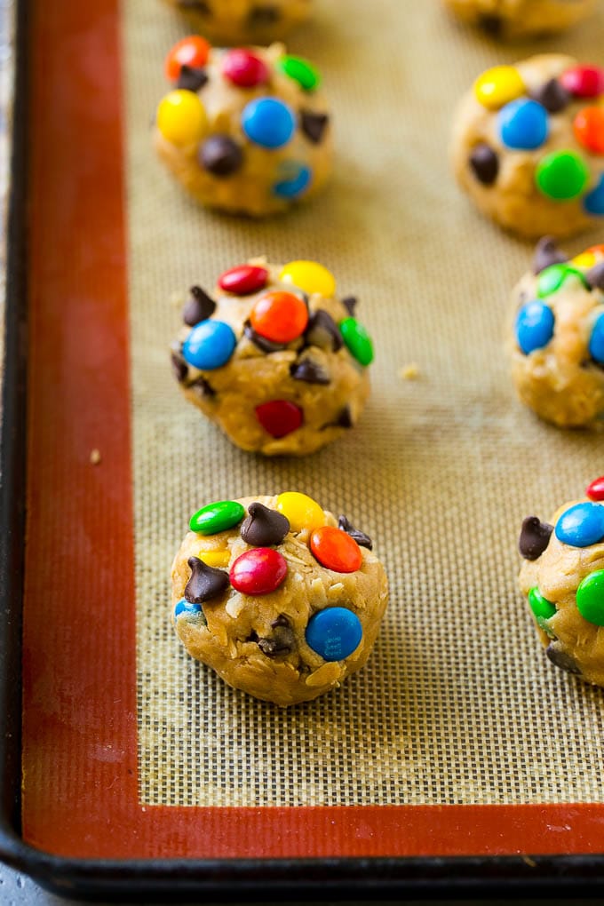 Monster Cookies Recipe | Oatmeal Cookies | Peanut Butter Cookies | M&M's Cookies #baking #cookies #dessert #peanutbutter #chocolate #sadud Balls of cookie dough on a baking sheet.