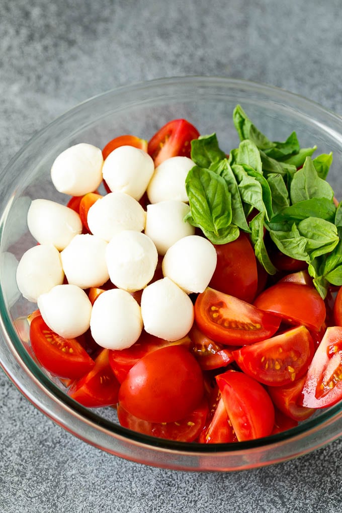 Caprese Salad Recipe | Tomato Salad #salad #tomato #mozzarella #cheese #basil #caprese #summer #sadud Tomatoes, mozzarella and basil in a bowl.