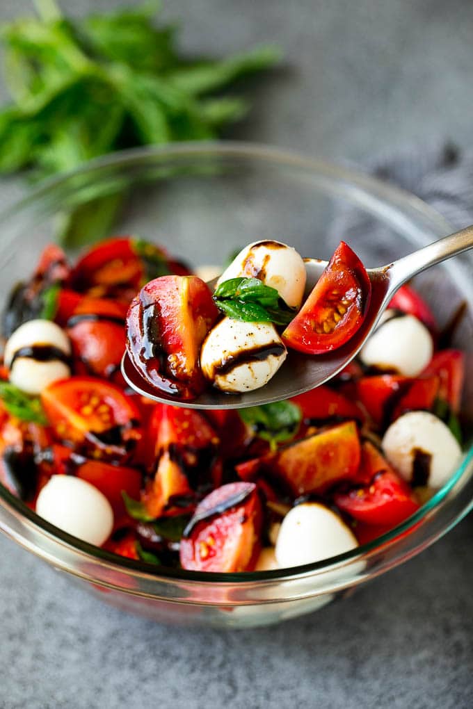 Caprese Salad Recipe | Tomato Salad #salad #tomato #mozzarella #cheese #basil #caprese #summer #sadud A serving spoon of caprese salad with tomato, mozzarella and basil.