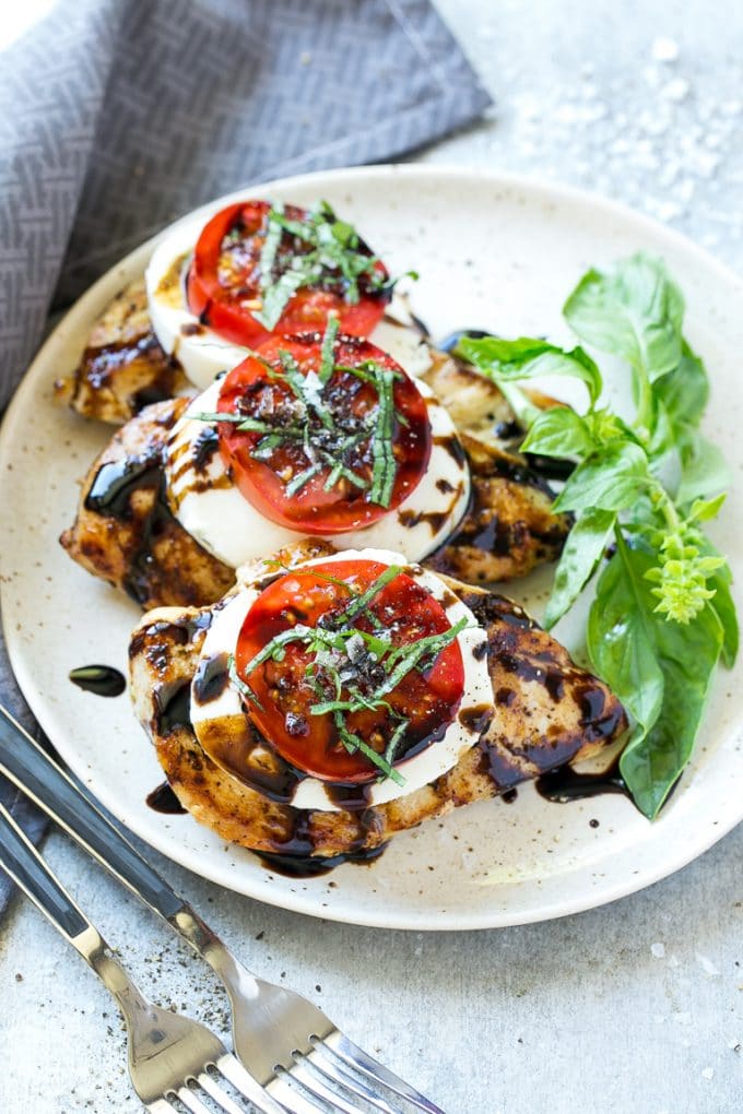 Chicken Caprese Recipe | Grilled Chicken #chicken #caprese #grilling #dinner #tomato #basil #sadud A plate of caprese chicken breasts topped with fresh mozzarella cheese, tomatoes and basil.