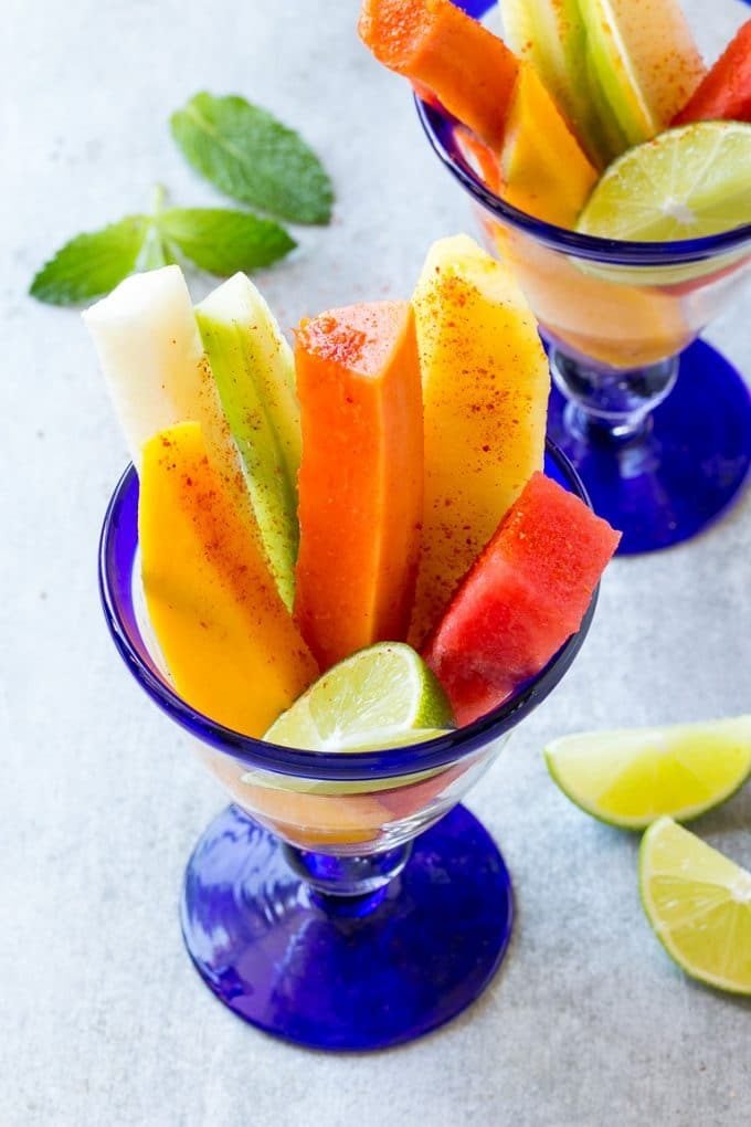 Mexican Fruit Cups | Fruit Cups | Mexican Fruit | Tropical Fruit #fruit #fruitcup #watermelon #pineapple #snack #healthy #sadud Spears of colorful fresh fruit, cucumbers and jicama in Mexican fruit cups.