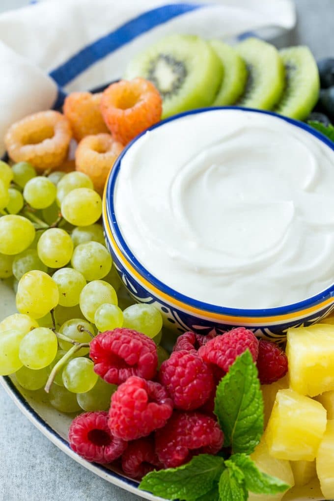 Cream Cheese Fruit Dip | Fruit Recipe | Fruit Dip #fruit #dip #creamcheese #snack #dessert #sadud A bowl of cream cheese fruit dip surrounded by grapes, raspberries and kiwis.