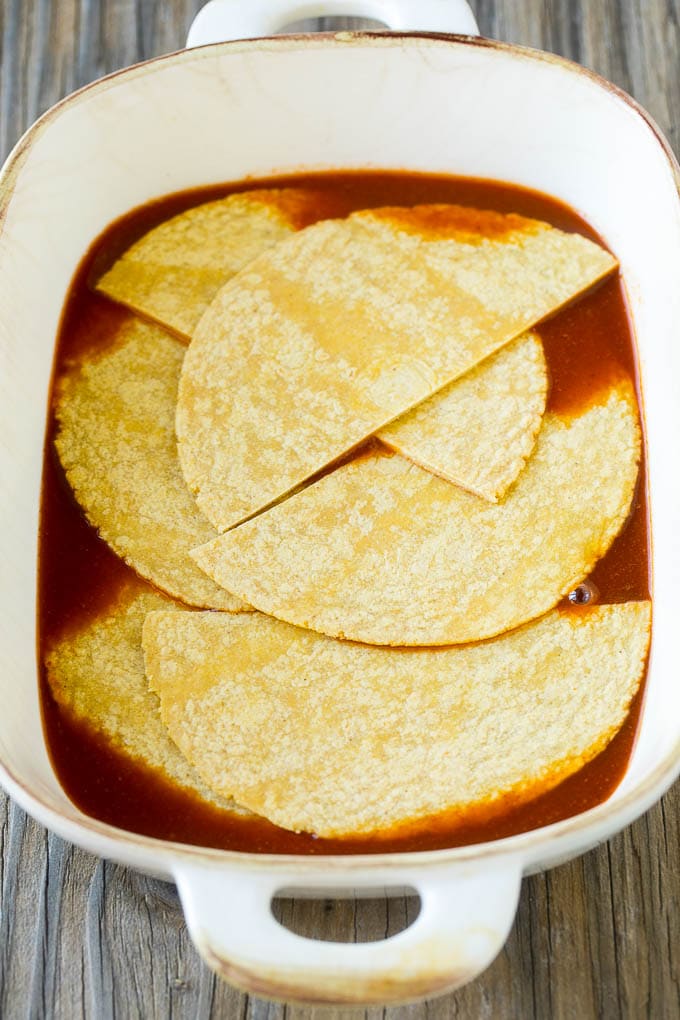 Chicken Enchilada Casserole Recipe | Chicken Enchiladas | Easy Casserole Recipe | Enchilada Casserole #chicken #casserole #enchiladas #cheese #beans #dinner #sadud Corn tortillas and enchilada sauce in a casserole dish.