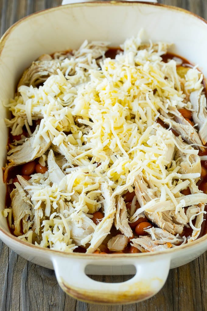 Chicken Enchilada Casserole Recipe | Chicken Enchiladas | Easy Casserole Recipe | Enchilada Casserole #chicken #casserole #enchiladas #cheese #beans #dinner #sadud Chicken, beans and shredded cheeses in a casserole dish.