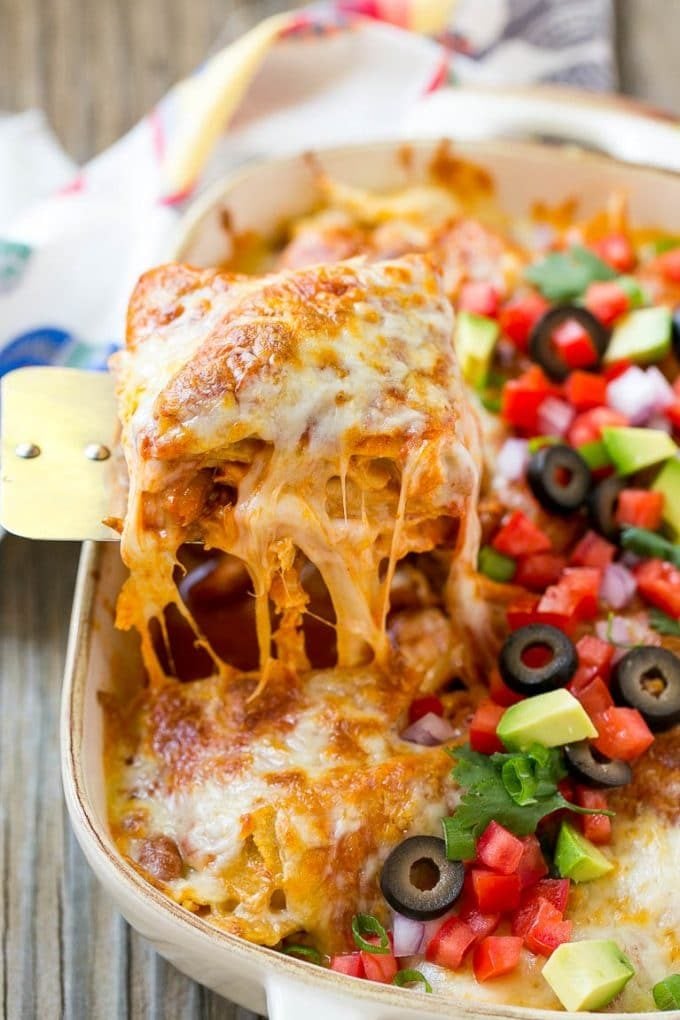 Chicken Enchilada Casserole Recipe | Chicken Enchiladas | Easy Casserole Recipe | Enchilada Casserole #chicken #casserole #enchiladas #cheese #beans #dinner #sadud A spatula serving up a portion of cheesy chicken enchilada casserole.