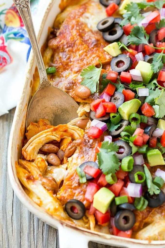 Chicken Enchilada Casserole Recipe | Chicken Enchiladas | Easy Casserole Recipe | Enchilada Casserole #chicken #casserole #enchiladas #cheese #beans #dinner #sadud A chicken enchilada casserole with a serving spoon in it.