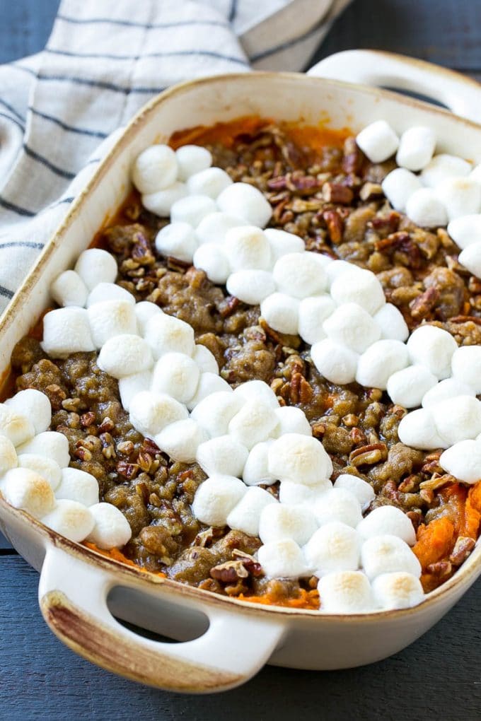 This recipe for sweet potato casserole with marshmallows is mashed spiced sweet potatoes, topped with both a pecan streusel topping and plenty of mini marshmallows. A holiday classic that's a family favorite! Sweet Potato Casserole in a baking dish.