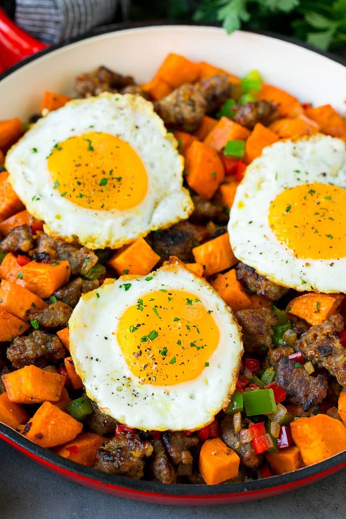 Sweet Potato Hash #sweetpotato #sausage #breakfast #brunch #sadud A pan of sweet potato hash topped with fried eggs.
