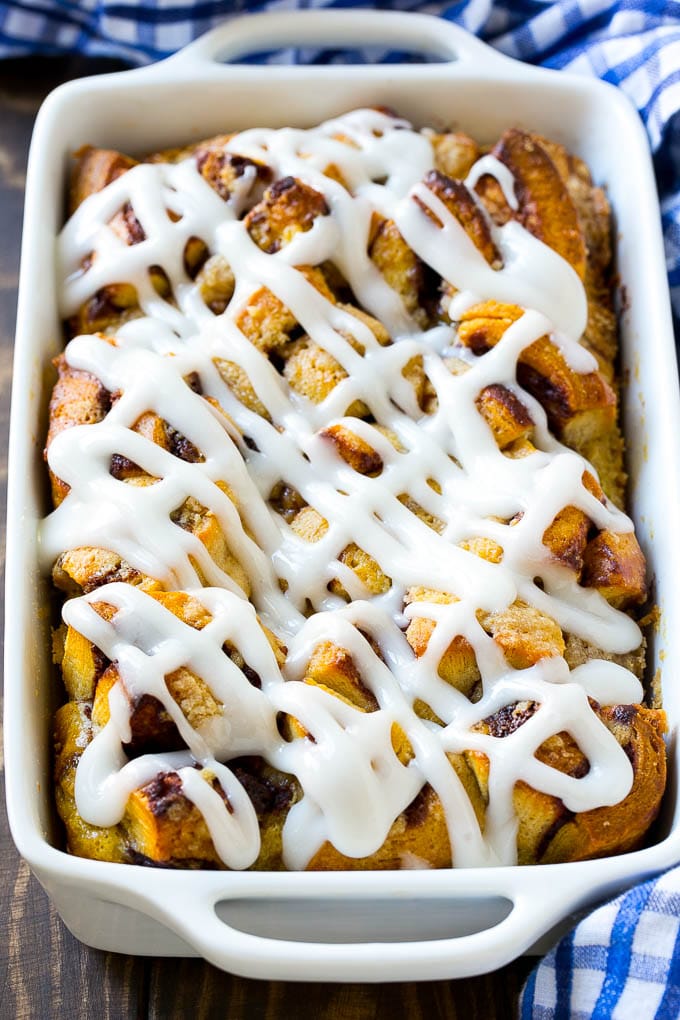 Cinnamon Roll French Toast Casserole | Cinnamon Roll French Toast Bake | Cinnamon Roll French Toast | Cinnamon French Toast #casserole #frenchtoast #cinnamonrolls #breakfast #sadud A casserole dish of cinnamon roll french toast with icing poured over the top.