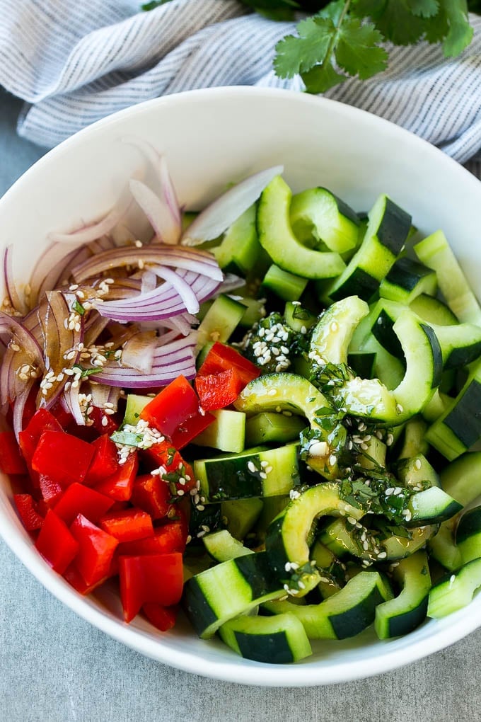 Asian Cucumber Salad Recipe | Sesame Cucumber Salad | Cucumber Salad | Healthy Salad | Healthy Cucumber Recipe #cucumber #cucumbersalad #salad #sidedish #sadud Sliced cucumbers, red peppers and onions with dressing.