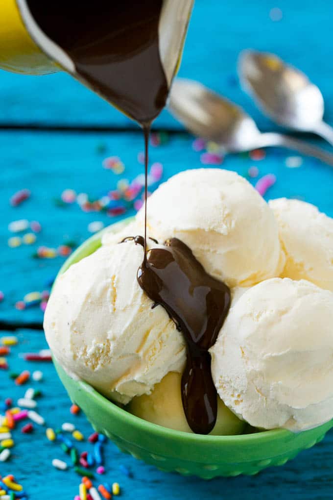 Homemade Magic Shell Recipe | Chocolate Ice Cream Topping | Chocolate Sauce | Hard Chocolate Coating #chocolate #icecream #dessert #sadud A pitcher of chocolate sauce being poured over vanilla ice cream.