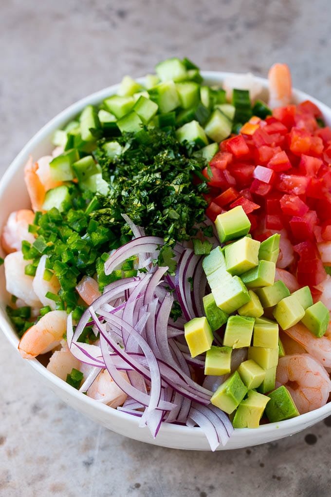 Shrimp Ceviche Recipe | Mexican Shrimp | Marinated Shrimp #shrimp #ceviche #cleaneating #healthy #lowcarb #keto #glutenfree #dinner #appetizer #sadud Prawns, avocado, red onion tomatoes, cilantro, jalapeno and cilantro in a bowl.