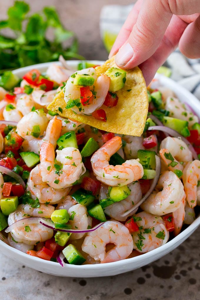 Shrimp Ceviche Recipe | Mexican Shrimp | Marinated Shrimp #shrimp #ceviche #cleaneating #healthy #lowcarb #keto #glutenfree #dinner #appetizer #sadud A bowl of shrimp ceviche with a tortilla chip scooping some out.
