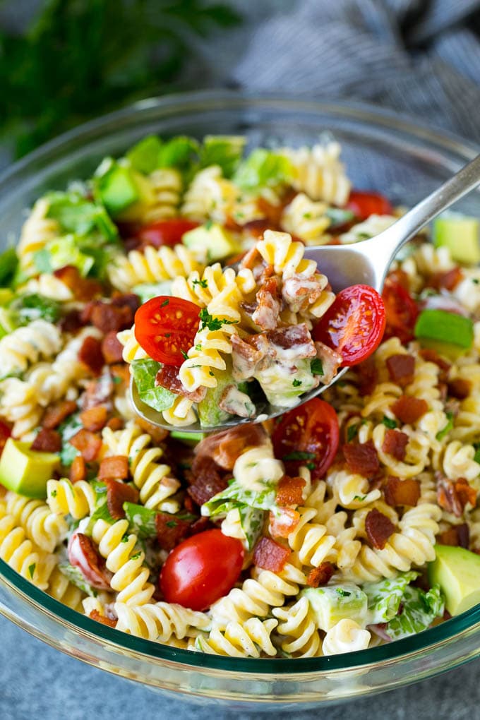 BLT Pasta Salad Recipe | Easy Pasta Salad | Bacon Pasta Salad #salad #pasta #blt #bacon #avocado #dinner #sadud A serving spoon filled with BLT pasta salad.