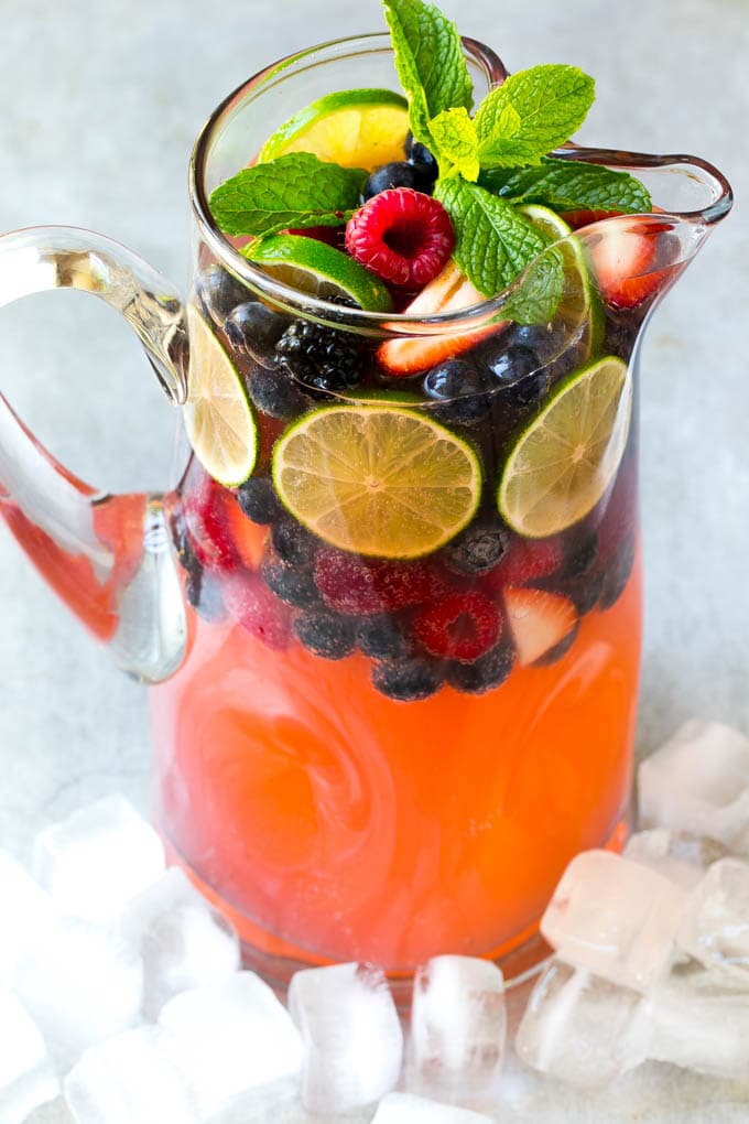 Berry Champagne Punch Recipe | Champagne Cocktail | Lime Cocktail | Berry Punch | Champagne Recipe #champagne #punch #berries #drink #sadud A pitcher of a cocktail garnished with fruit and mint.