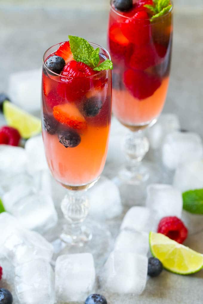 Berry Champagne Punch Recipe | Champagne Cocktail | Lime Cocktail | Berry Punch | Champagne Recipe #champagne #punch #berries #drink #sadud Two champagne flutes filled with berry champagne punch garnished with berries.
