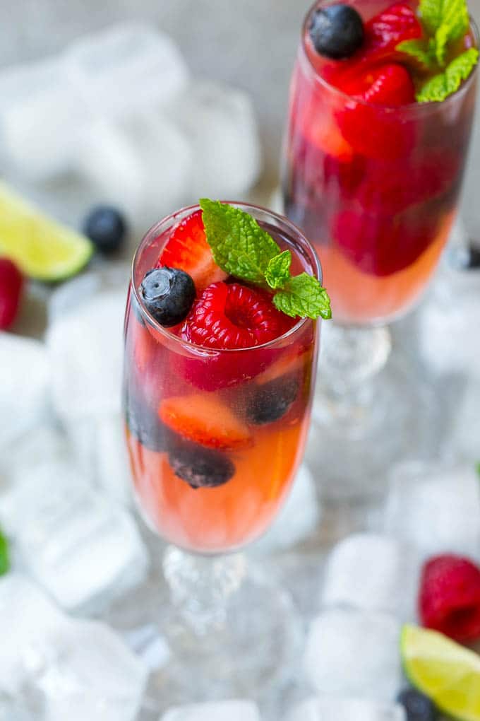 Berry Champagne Punch Recipe | Champagne Cocktail | Lime Cocktail | Berry Punch | Champagne Recipe #champagne #punch #berries #drink #sadud Two glasses of refreshing champagne punch with berries and mint on top.