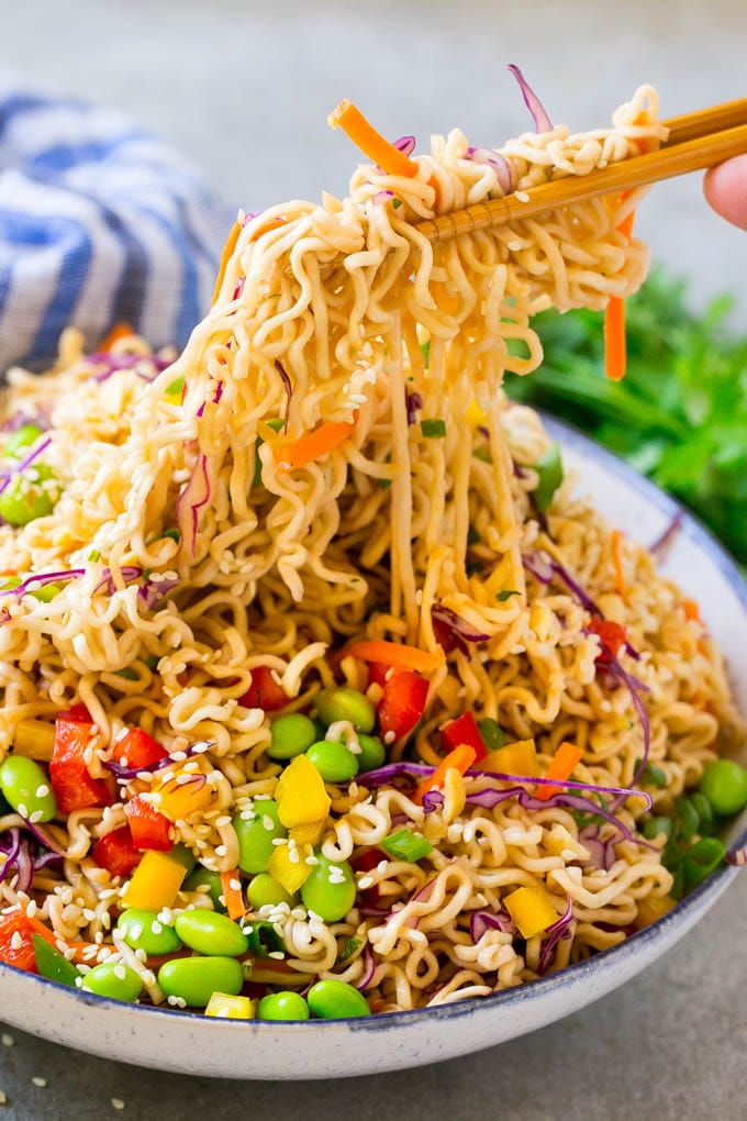 Asian Noodle Salad Recipe | Ramen Noodle Salad | Asian Salad #salad #noodles #edamame #vegetarian #sadud #lunch Chopsticks picking up noodles in a vegetable salad.
