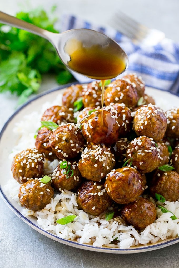 Teriyaki Meatballs Recipe | Asian Meatballs Recipe | Easy Meatball Recipe | Appetizer Meatballs #meatballs #teriyaki #beef #rice #dinner #sadud Teriyaki sauce spooned over a pile of meatballs on a bed of rice.