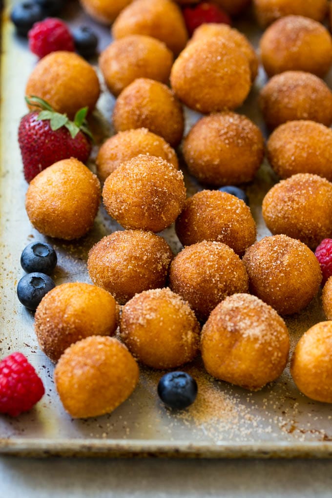 Donut Bread Pudding Recipe | Easy Bread Pudding | Cinnamon Donuts | Make Ahead Breakfast Recipe #breadpudding #donuts #donutholes #breakfast #sadud Cinnamon sugar donut holes on a tray surrounded by berries