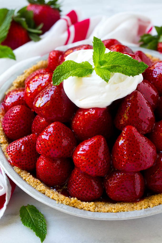 No Bake Strawberry Pie Recipe | Fresh Strawberry Pie | Strawberry Pie Recipe | No Bake Pie Recipe #strawberry #strawberrypie #nobake #nobakepie #dessert #sadud Strawberry pie with a pile of strawberries inside a graham cracker crust, topped with glaze and whipped cream.