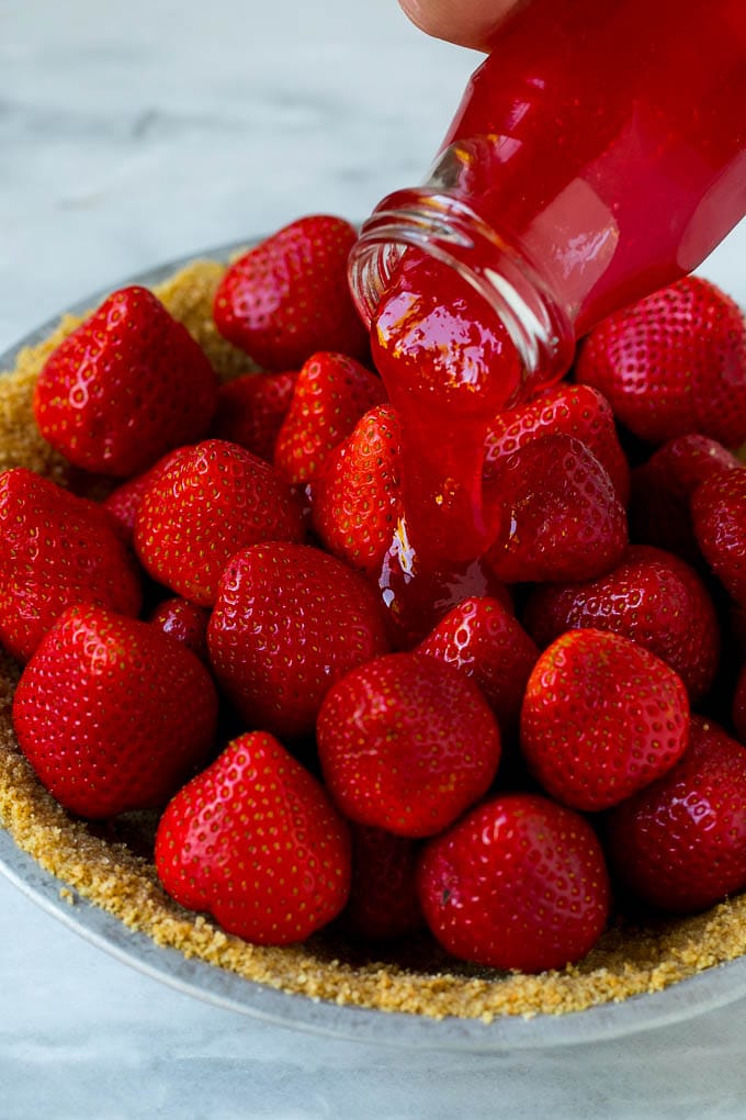 No Bake Strawberry Pie Recipe | Fresh Strawberry Pie | Strawberry Pie Recipe | No Bake Pie Recipe #strawberry #strawberrypie #nobake #nobakepie #dessert #sadud Glaze being poured over a strawberry pie.