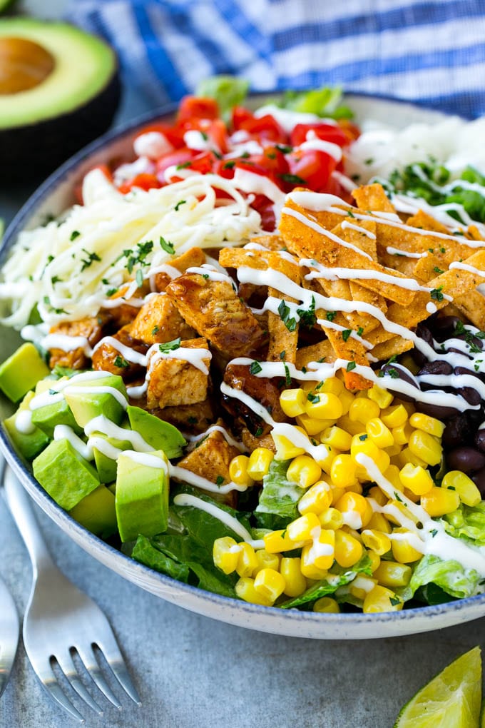 BBQ Chicken Salad Recipe | Chopped BBQ Chicken Salad | CPK Copycat Recipe | California Pizza Kitchen Copycat Recipe | Chicken Ranch Salad #copycat #CPK #BBQchicken #chicken #salad #dinner #sadud A bowl of BBQ chicken salad topped with a drizzle of ranch dressing.
