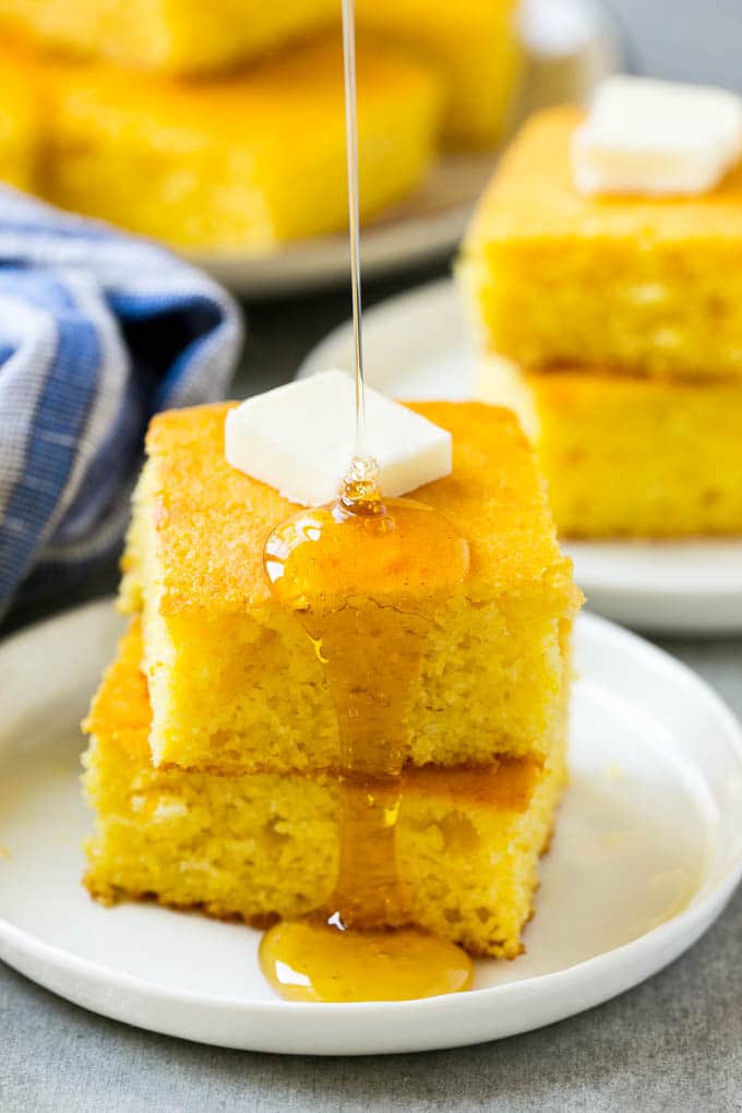 Honey Cornbread Recipe | Buttermilk Cornbread | Easy Cornbread | Homemade Cornbread | Cast Iron Cornbread #cornbread #honey #buttermilk #bread #sadud A stack of cornbread topped with butter and honey