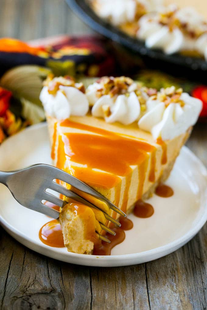 No Bake Pumpkin Cheesecake Recipe | Pumpkin Cheesecake | No Bake Cheesecake | Thanksgiving Dessert | Pumpkin Dessert #nobake #cheesecake #pumpkin #pumpkinpie #pumpkincheesecake #nobakecheesecake #dessert #sadud A fork cutting into a slice of no bake pumpkin cheesecake.