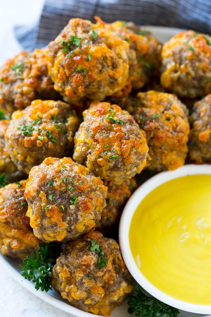 Sausage Cheese Balls Recipe | Sausage Balls Recipe | Bisquick Sausage Balls #sausage #sausageballs #balls #appetizer #cheeseballs #sadud A platter of sausage cheese balls with honey mustard sauce for dipping.
