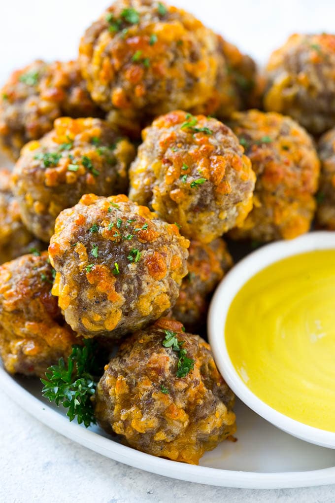 Sausage Cheese Balls Recipe | Sausage Balls Recipe | Bisquick Sausage Balls #sausage #sausageballs #balls #appetizer #cheeseballs #sadud A pile of sausage cheese balls with a side of honey mustard.