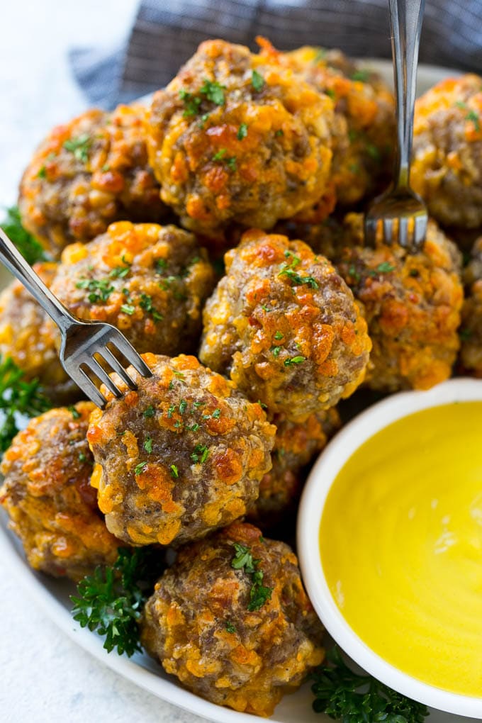 Sausage Cheese Balls Recipe | Sausage Balls Recipe | Bisquick Sausage Balls #sausage #sausageballs #balls #appetizer #cheeseballs #sadud A plate of meatballs with cocktail forks.