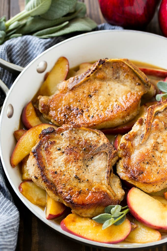 Apple Pork Chops Recipe | Pork Chops with Apples | Cider Pork Chops | Bone In Pork Chops Recipe #pork #porkchops #fall #apple #dinner #sadud A pan of apple pork chops garnished with fresh sage.