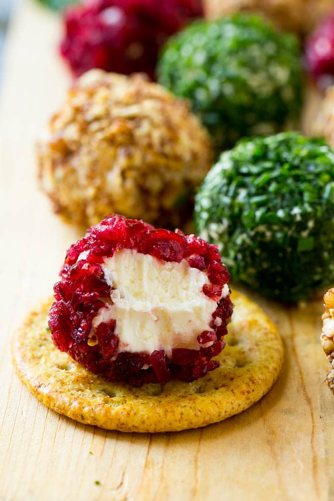 Cheese Ball Bites Recipe | Holiday Cheese Ball Recipe | Pecan Cheese Ball | Cranberry Cheese Ball | Mini Cheese Balls #cheeseball #cheese #appetizer #sadud A cranberry crusted ball of cheese on a cracker.