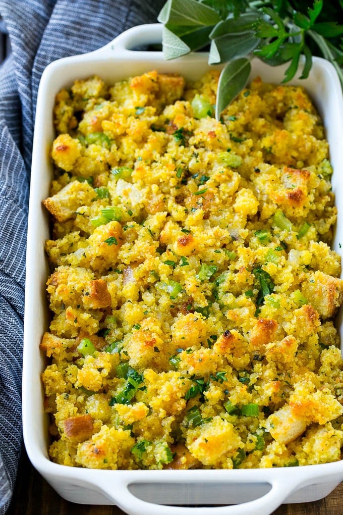 This old fashioned Southern cornbread dressing recipe is a classic that's a must-have for every Thanksgiving table. It's made with celery, onions, homemade cornbread, white bread and plenty of herbs. Cornbread Dressing in a white baking dish garnished with fresh herbs.