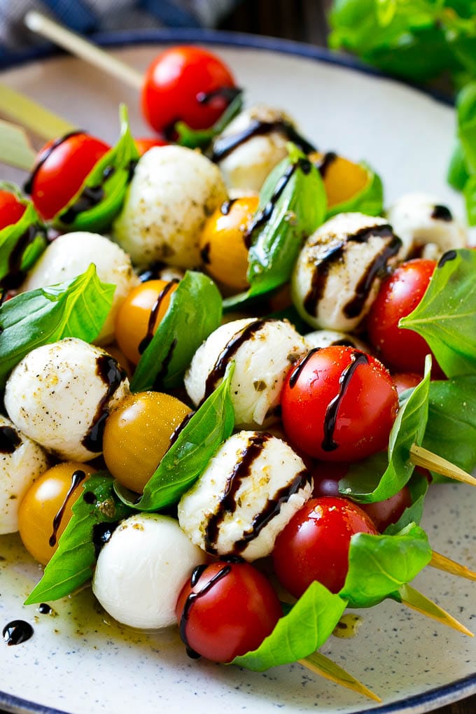 Caprese Skewers | Caprese Kabobs | Caprese Appetizer #tomato #mozzarella #basil #caprese #appetizer #sadud A plate of caprese skewers with mozzarella, tomatoes and basil.